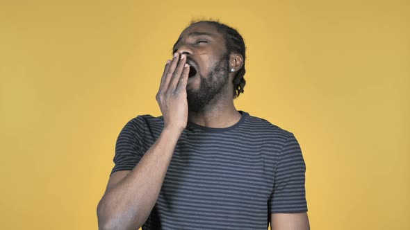 Casual African Man Yawning and Stretching BodyIsolated on Yellow Background