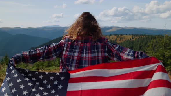 Woman Hiking in Mountains with American Flag