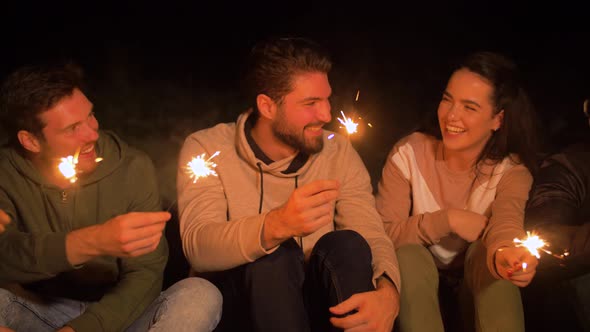 Happy Friends with Sparklers at Night Outdoors