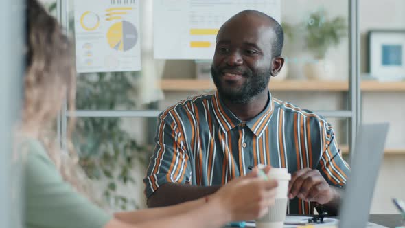 Afro-American Businessman Talking with Colleague at Office Meeting