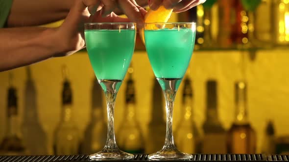 Barman Puts Cubes of Ice Into a Glass, Pouring Three Different Alcohol Liquids, Turquoise, Using