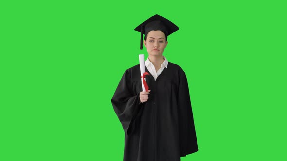 Frustrated Female Student in Graduation Robe Shaking Her Diploma While Waiting on a Green Screen