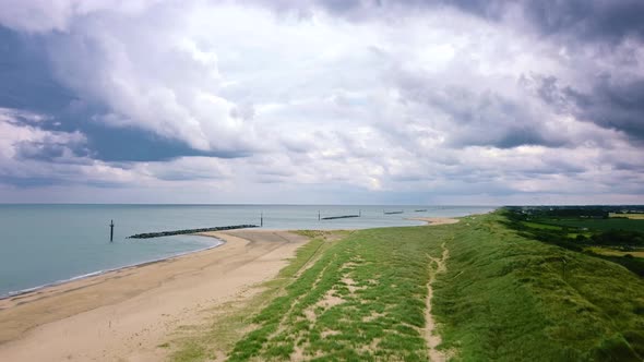 A storm brews with grey moody clouds over a beautiful beach seascape, Britain