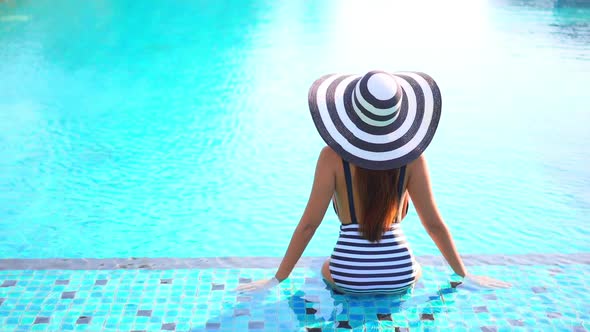 Young asian woman enjoy around outdoor swimming pool for leisure