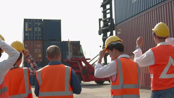 Engineer and worker team wearing safety helmet and reflective vest before walking inside Shipping Co