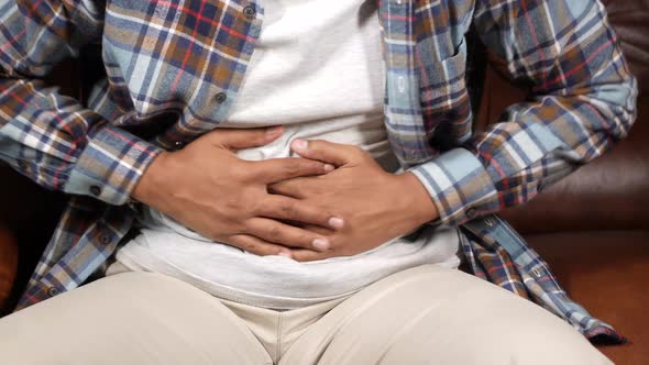 Young Man Suffering Stomach Pain Close Up