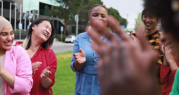 Young multiethnic people having fun clapping hands outdoor