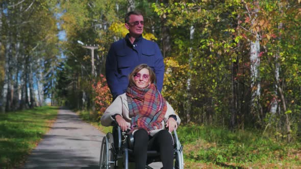 Man walking with woman on wheelchair