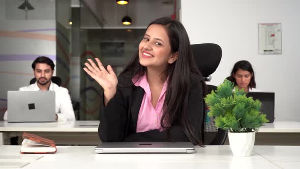 Happy Indian corporate girl waving Hi to the camera