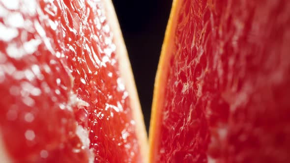 Macro Video of Camera Moving Between Two Halves of Cut Grapefruit Against Black Backgorund. Perfect