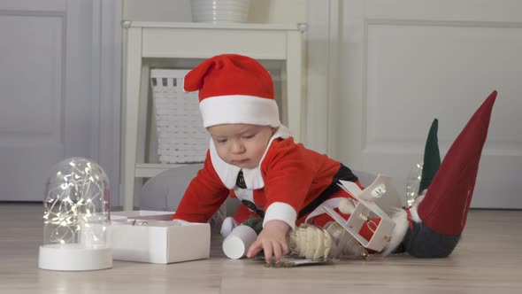 Cute Happy Baby Boy in Santa Hat Playing with New Christmas Decorations Kid Have Fun Spend New Year