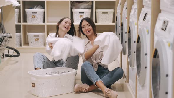 Two Happy Girlfriends Having Fun Together While Washing Selfservice Laundry