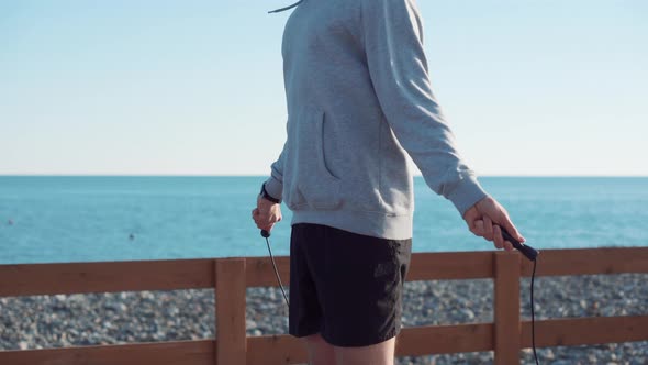 Sportsman Is Jumping Rope in Sunny Day Near Sea