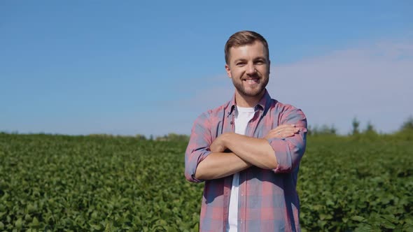 A Young Farmer Stands in the Middle of a Soybean Field