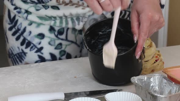 A Woman Greases A Baking Dish With Butter. Prepares Cruffin With Raisins And Candied Fruit