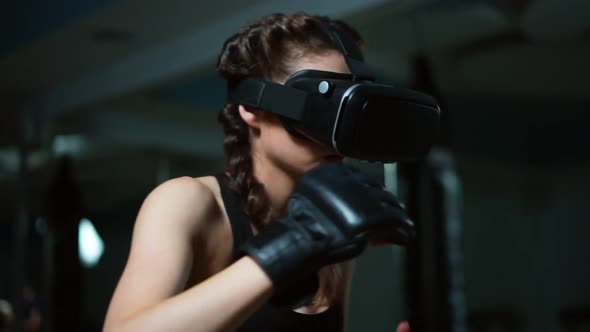 Young Attractive Woman Boxing in VR 360 Headset Training for Kicking in Virtual Reality