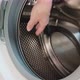 Young woman housewife puts dirty socks into washing machine - VideoHive Item for Sale