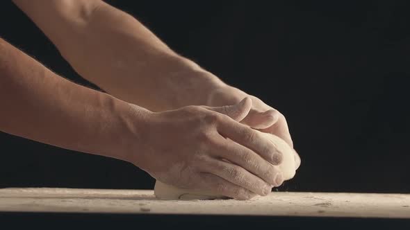 Male Hands Throw a Piece of Dough to a Wooden Table and Sprinkle It with Flour