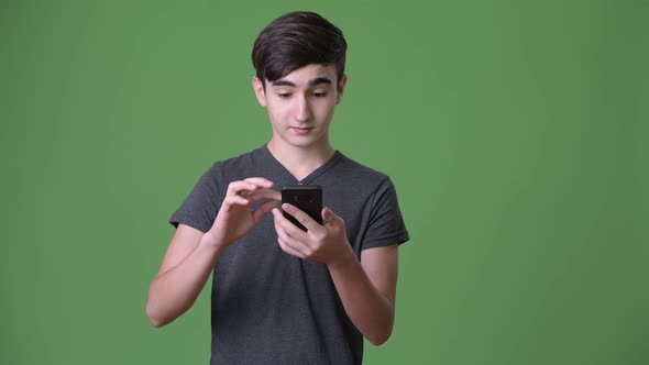 Young Handsome Iranian Teenage Boy Against Green Background