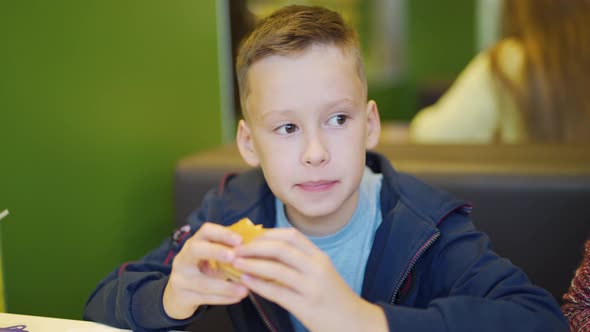 Young Teenager Eating Tasty Hamburger