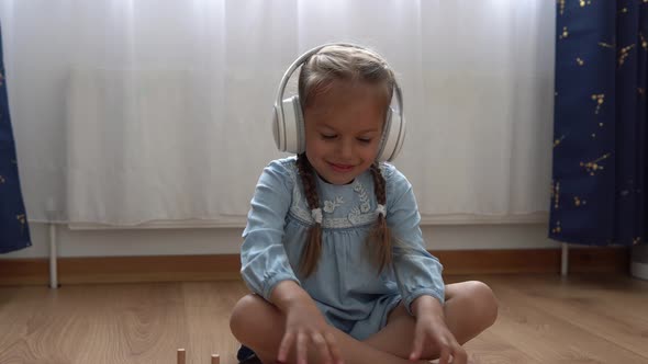 Child Listening Music In Big White Headphones