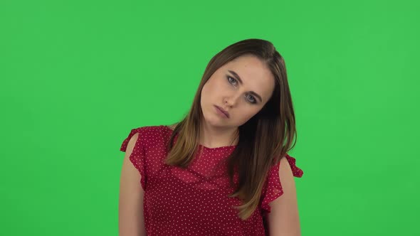 Portrait of Tender Girl in Red Dress Is Upset and Tired. Green Screen