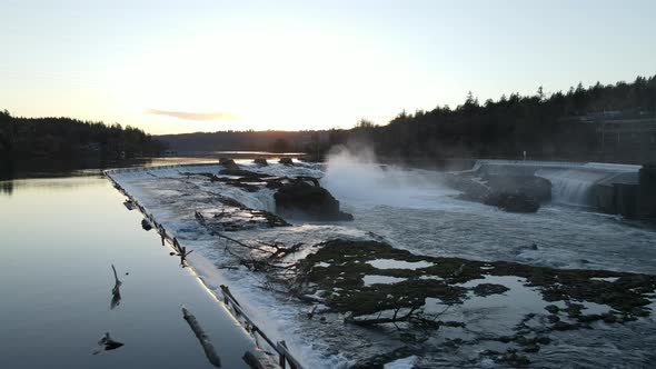 Flying Over a Dam with Waterfalls During Sunset