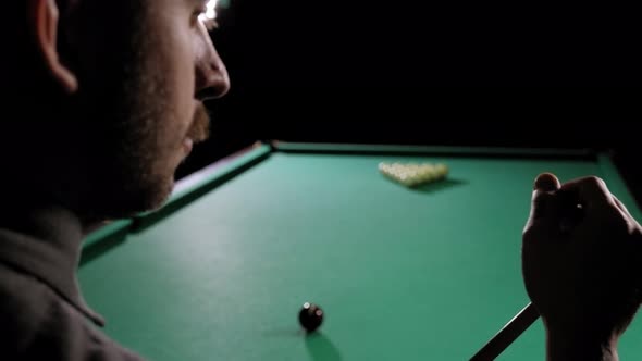 Handsome Bearded Man Rubbing Cue with Chalk at Bar