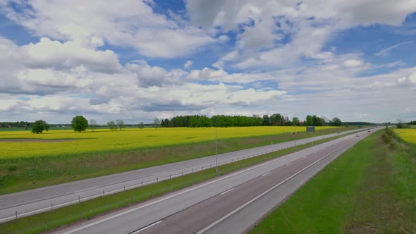 Beautiful top view of highway with several cars. Green side fields and clouds sky background. Sweden