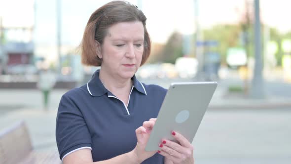 Old Woman Using Digital Tablet Outdoor