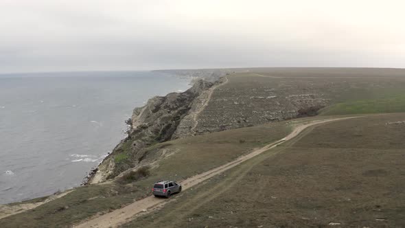 Aerial Follow Tracking Shot High Speed Suv Car Driving on Top of Mountain Road Natural Sky Seascape