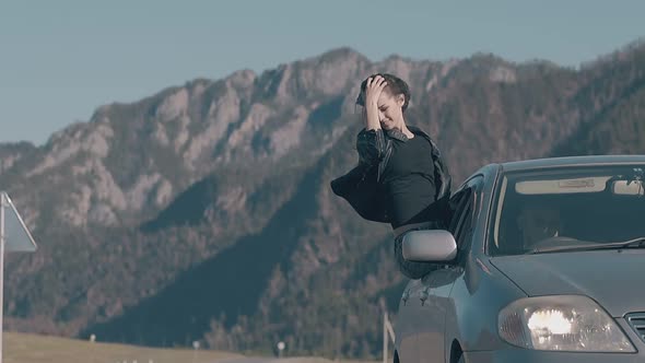 Lady with Long Dark Hair Sits on Car Window and Enjoys Life