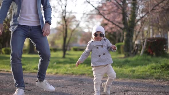 Adorable Little Gilr Spend Time with Her Father. Dad and Daughter Walk in the Park. Stylish Family