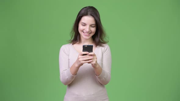 Young Happy Beautiful Woman Using Phone Against Green Background