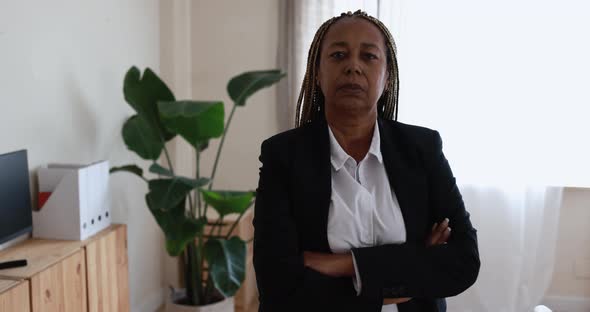 African senior woman looking on camera inside modern office