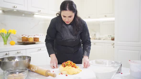 Women Kneads Dough with Candied Fruits for Easter Cakes