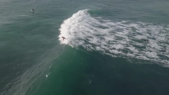 Surfer in board shorts catches a wave on Buffalo Bay, Africa aerial