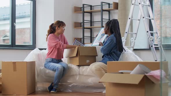 Women Unpacking Boxes and Moving to New Home