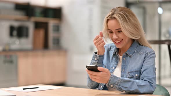 Young Casual Woman Cheering on Smartphone at Work, Success 
