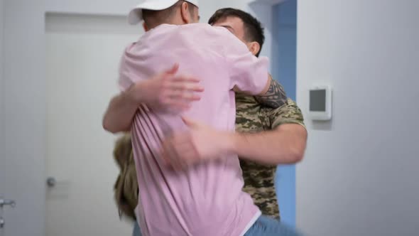 Happy Gay Soldier Returning Home As Boyfriend Jumping on Hips Hugging Lover Smiling