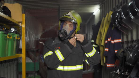 A caucasian firefighter or fireman with uniform and mask, wearing safety helmet