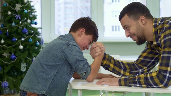 Father and Son Armwrestle on the Table