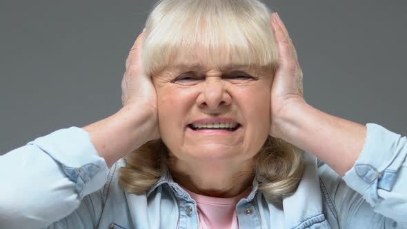 Annoyed Grandmother Covering Ears by Hands, Loud Sound Stress, Feeling Headache