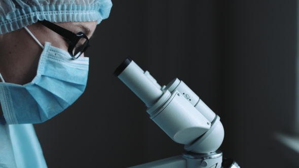 Female Scientist Looking Through Microscope