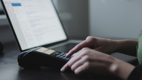 Woman Uses Credit Card Terminal in Office.