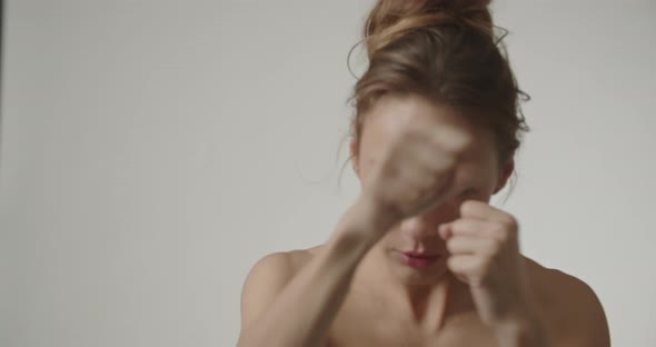 Young Woman With Fists Raised And Throwing Punches