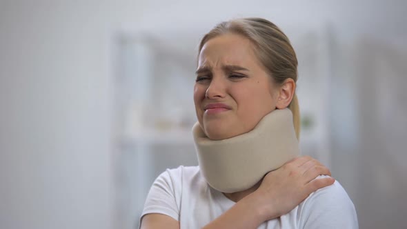 Upset Girl in Foam Cervical Collar Suffering Pain in Back and Shoulder, Injury