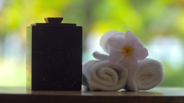 Placing Fresh Towels with Flower on the Table in Spa