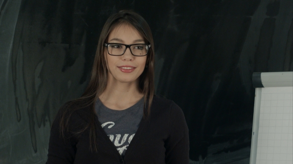 Smiling Brunette in Glasses Presenting Her Work with Flipchart