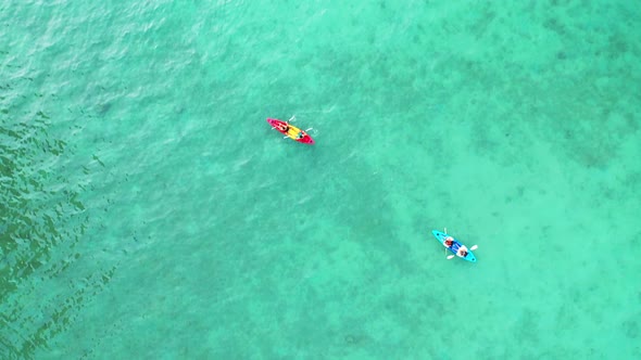 4K Aerial view of Young Asian man and woman friends kayaking together in the sea on summer vacation.